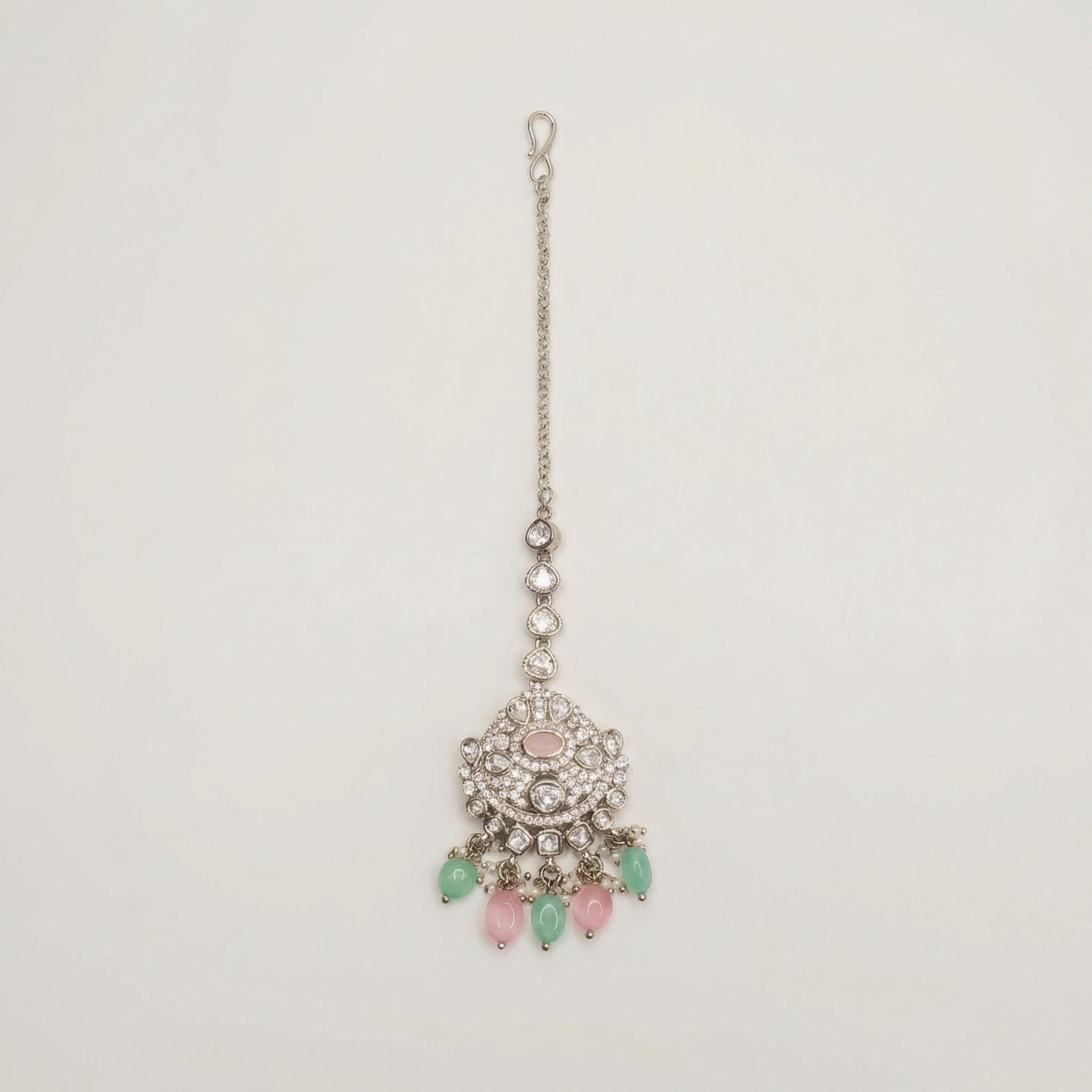 Mridul Tikka silver maang tikka with pink center and mint green pink teardrop beads on gray background