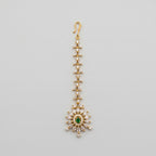 Emerald Star Tikka gold-tone maang tikka with green starburst pendant on gray background