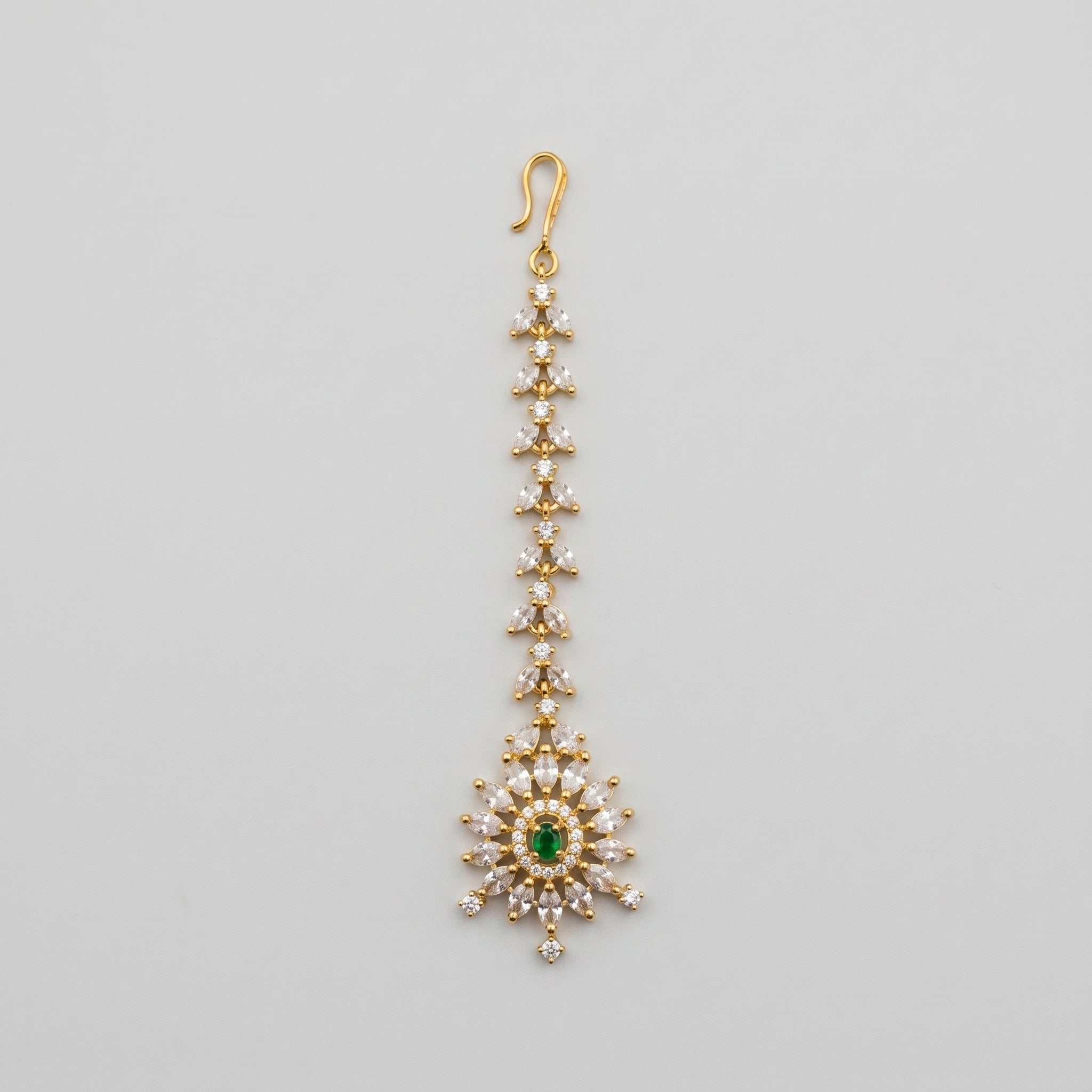 Emerald Star Tikka gold-tone maang tikka with green starburst pendant on gray background