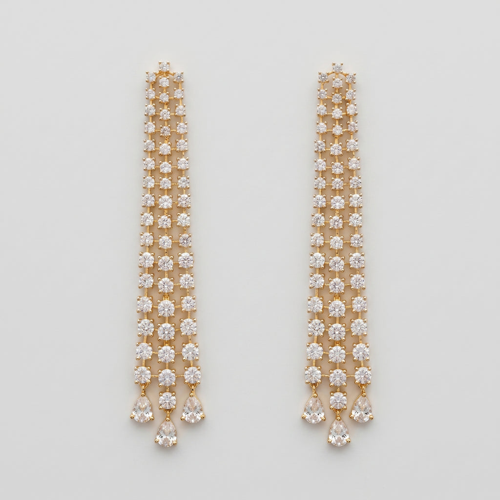 Hira Stream Earrings gold-tone crystal waterfall chandelier earrings with pear teardrop drops on gray background