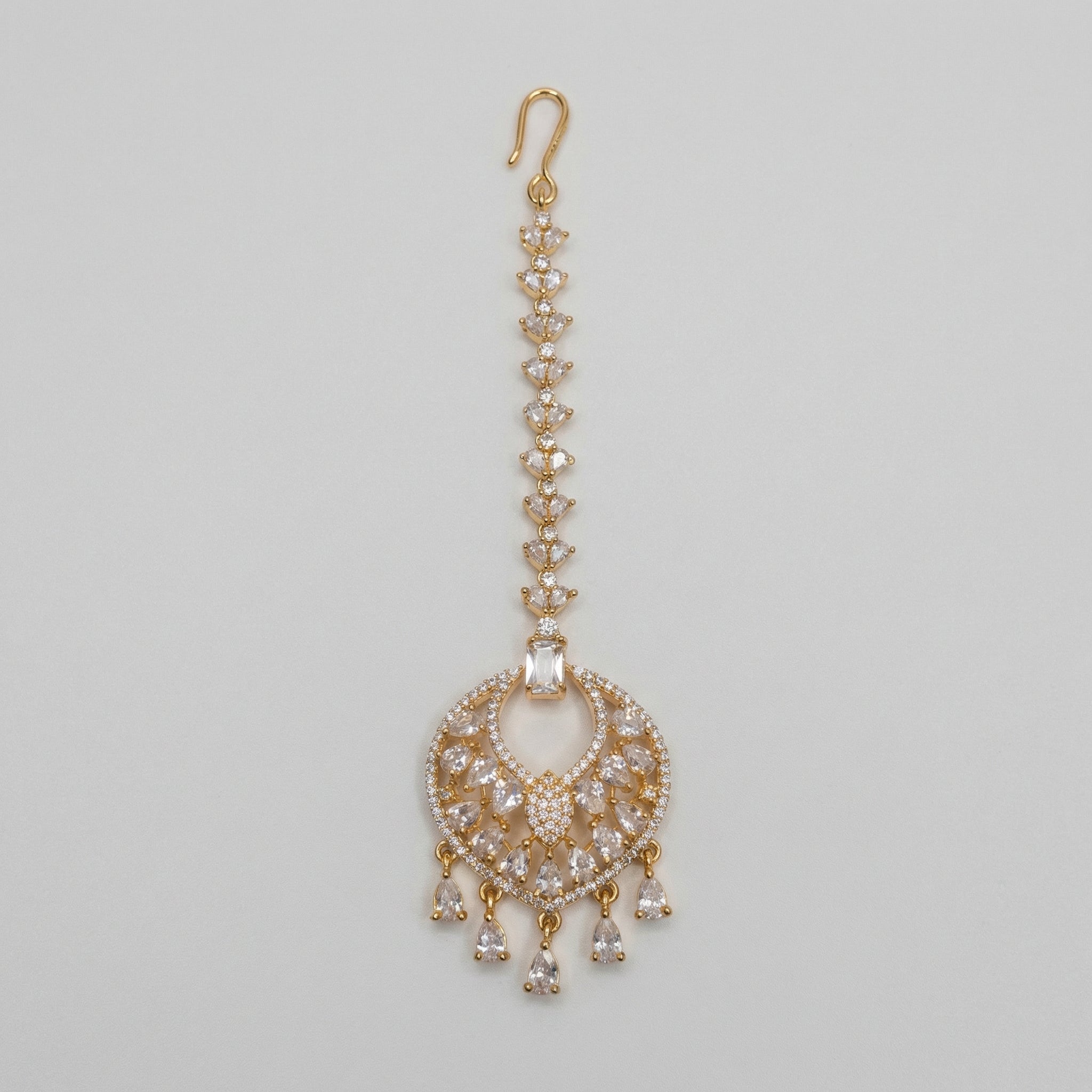 Amala Zircon Tikka gold maang tikka with marquise crystal chain round medallion and pear drops on gray background