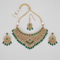 Majestic Emerald Choker Set gold emerald choker with earrings and maang tikka on gray background