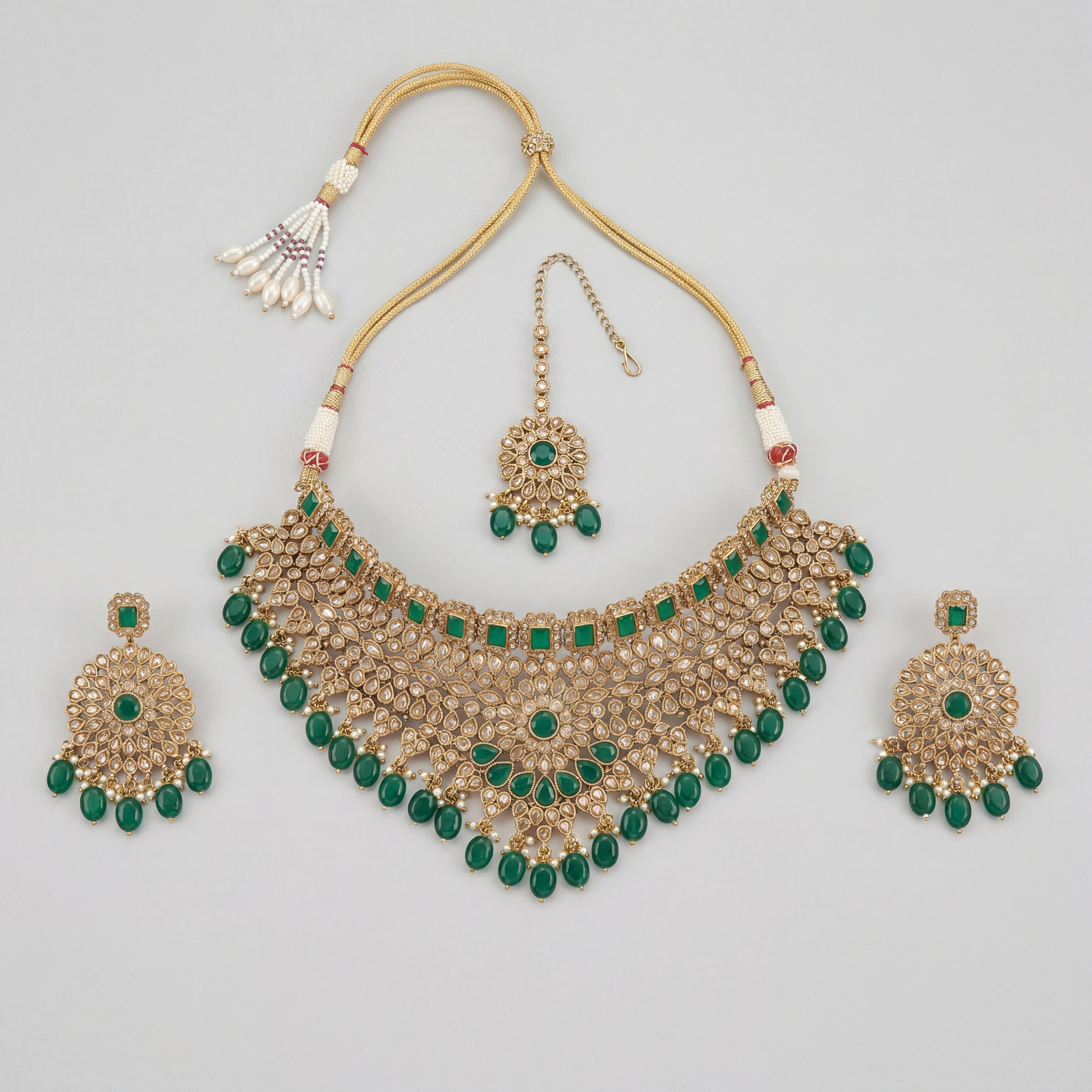 Majestic Emerald Choker Set gold emerald choker with earrings and maang tikka on gray background