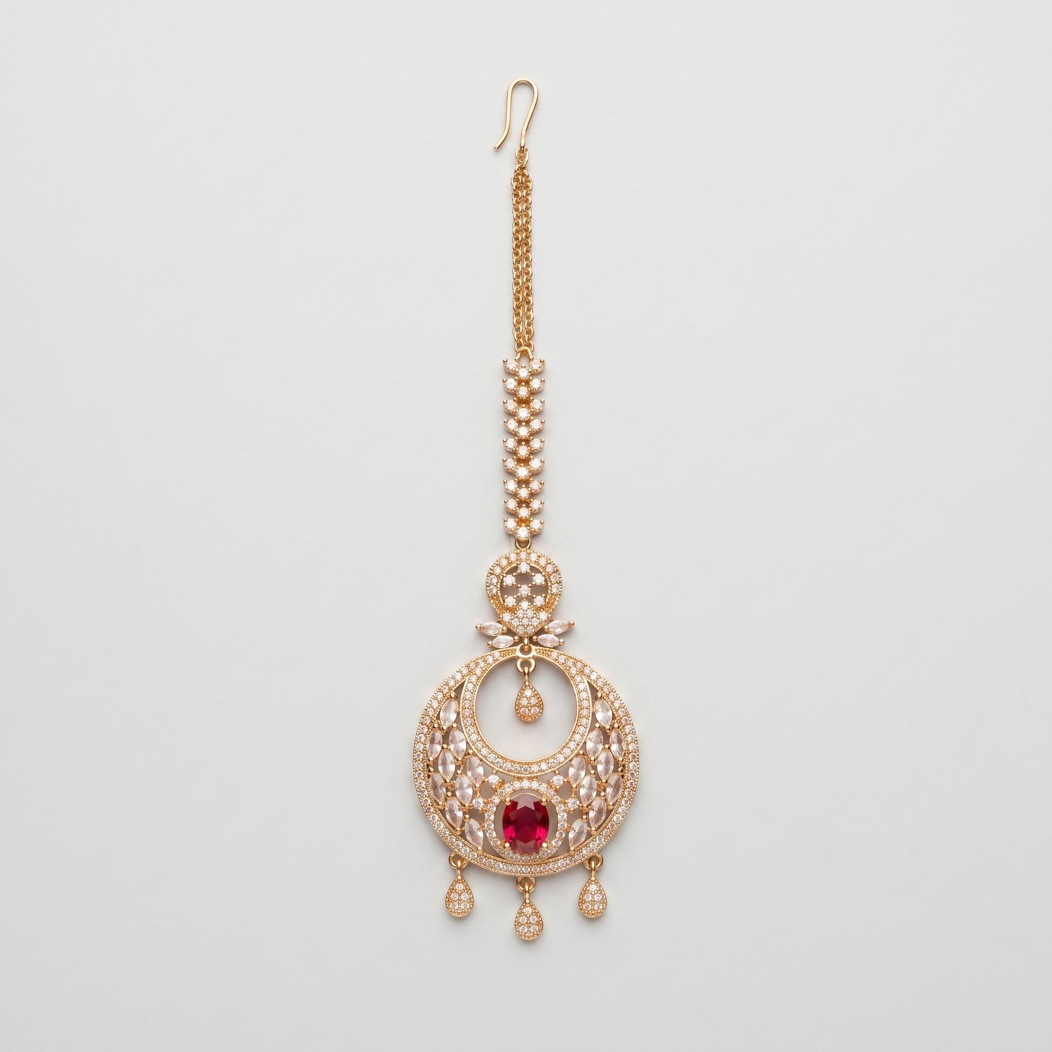 Ruby Tikka gold chandbali maang tikka with ruby red oval center on gray background