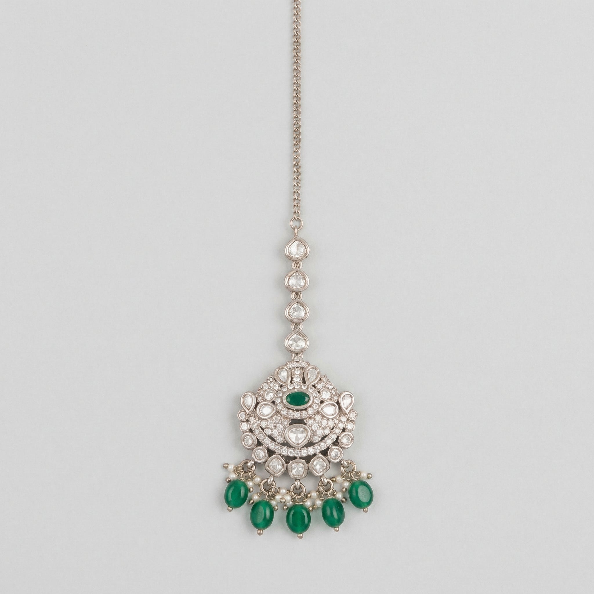 Noor Emerald Tikka silver maang tikka with green center stone and green teardrop bead fringe on gray background