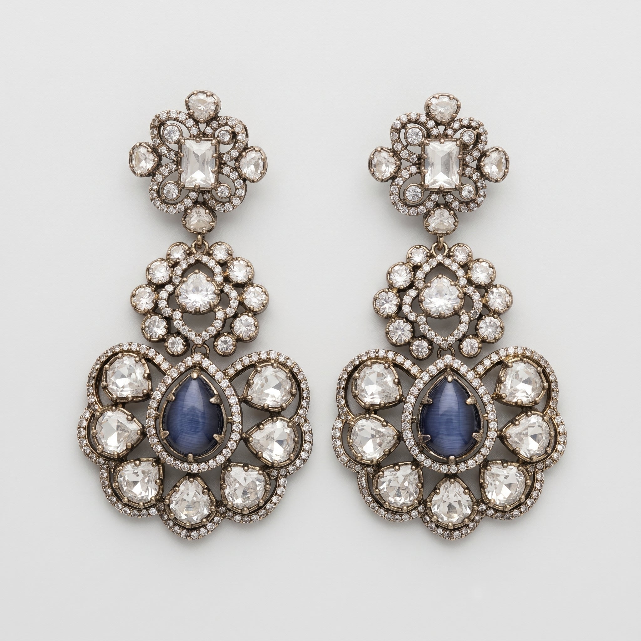 Neelam Bloom Earrings oxidized silver chandelier drops with blue cat's eye pear stones on gray background
