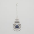 Adah Sapphire Tikka silver maang tikka with blue floral center and clear teardrop dangles on gray background
