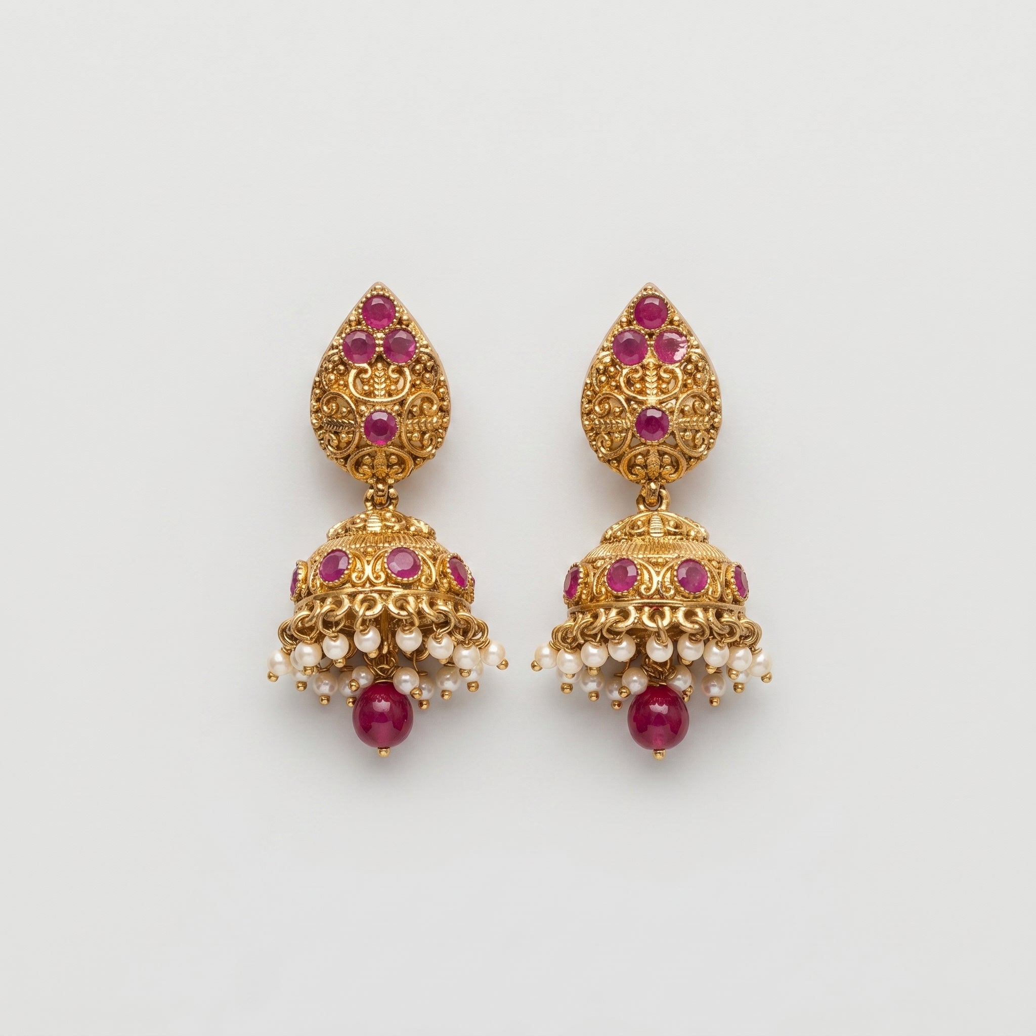 Ruby Pearl Earrings gold jhumka drops with ruby stones and pearl fringe on gray background
