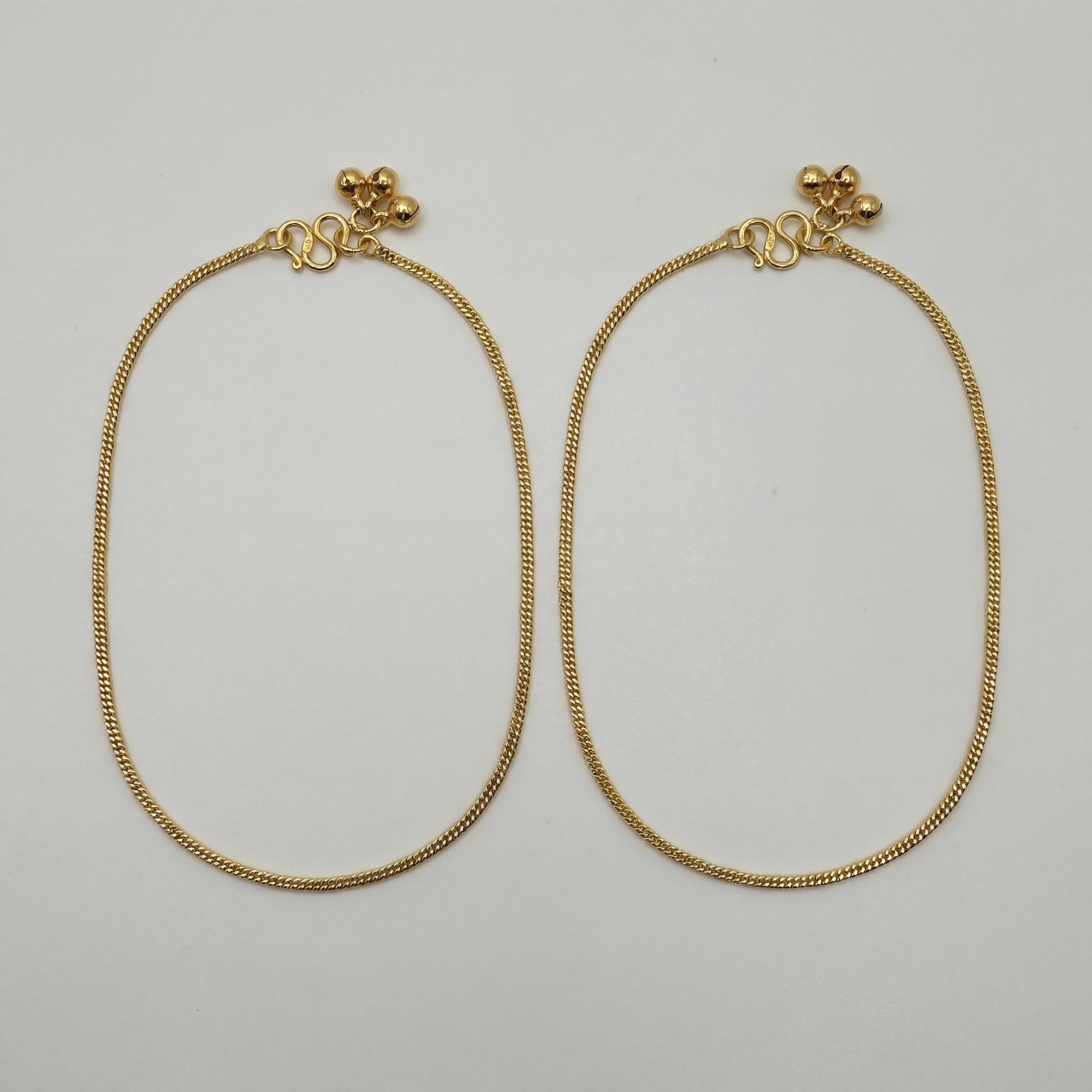 Sutra Anklet pair of gold-tone curb chain payals with ball charms on white background