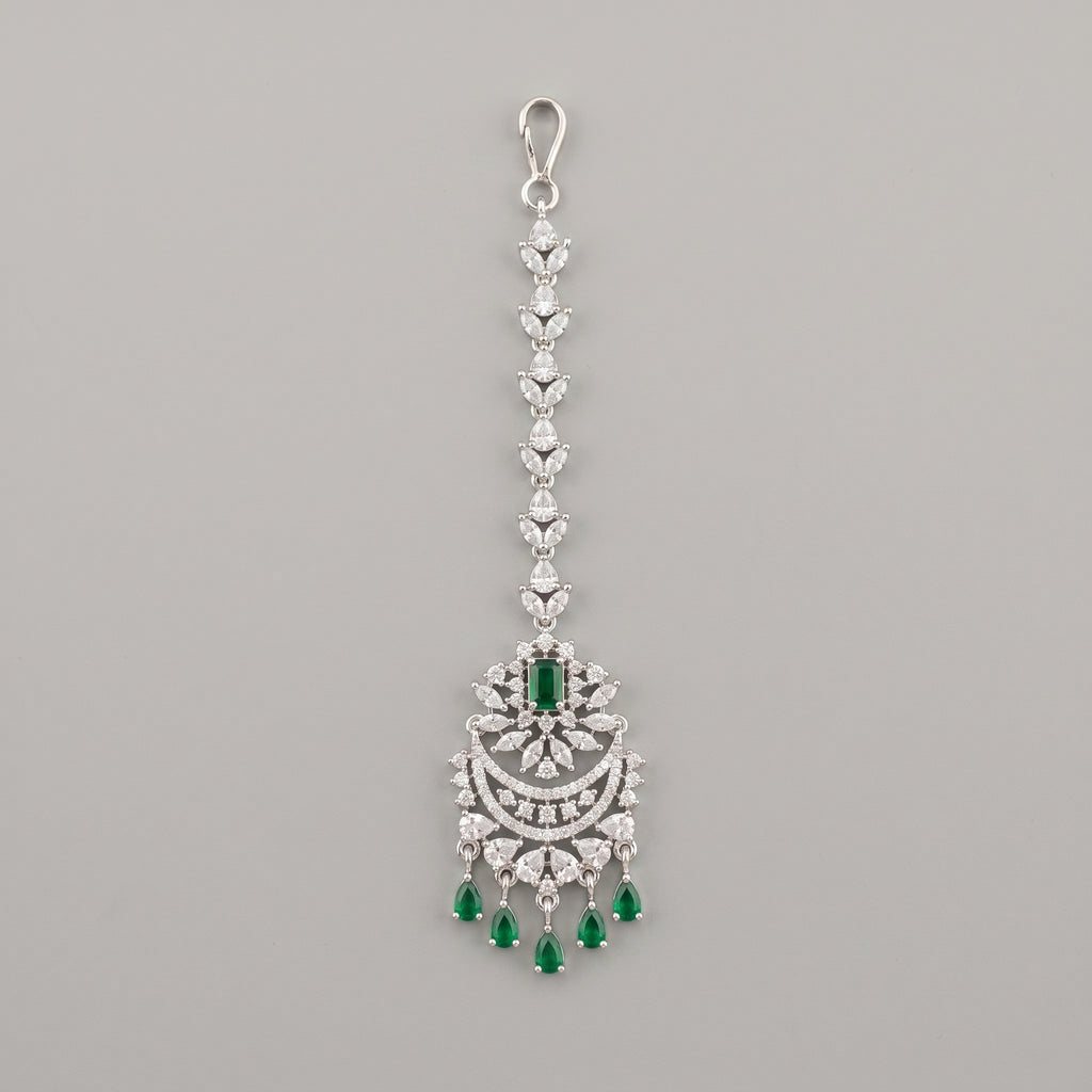Sia Emerald Tikka silver maang tikka with green stones and chaandbali pendant on gray background