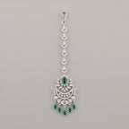 Sia Emerald Tikka silver maang tikka with green stones and chaandbali pendant on gray background