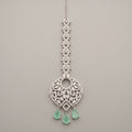 Panna Crystal Tikka silver-tone maang tikka with green teardrop drops on gray background