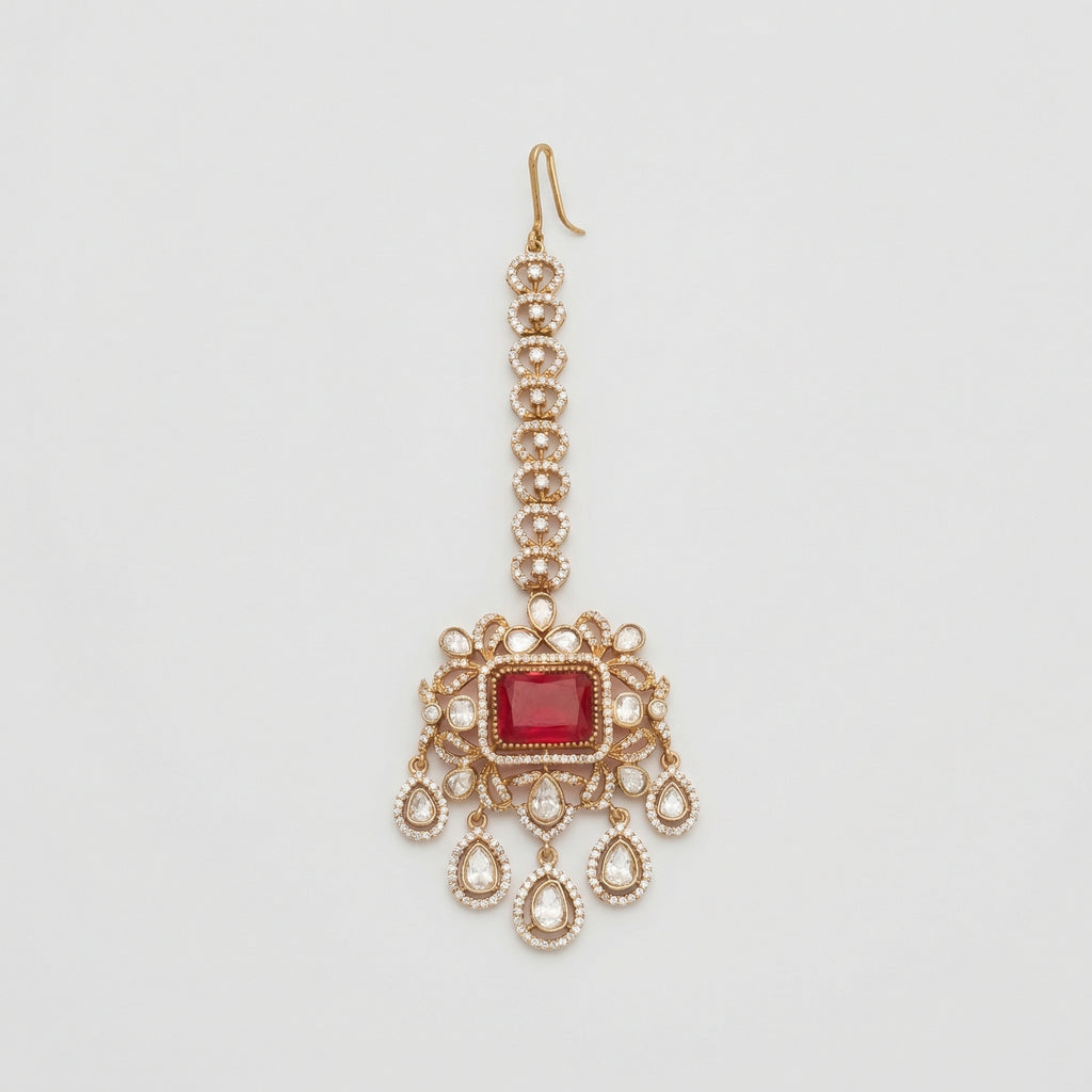 Kundan Ruby Tikka gold maang tikka with ruby red center and five teardrop crystal dangles on gray background