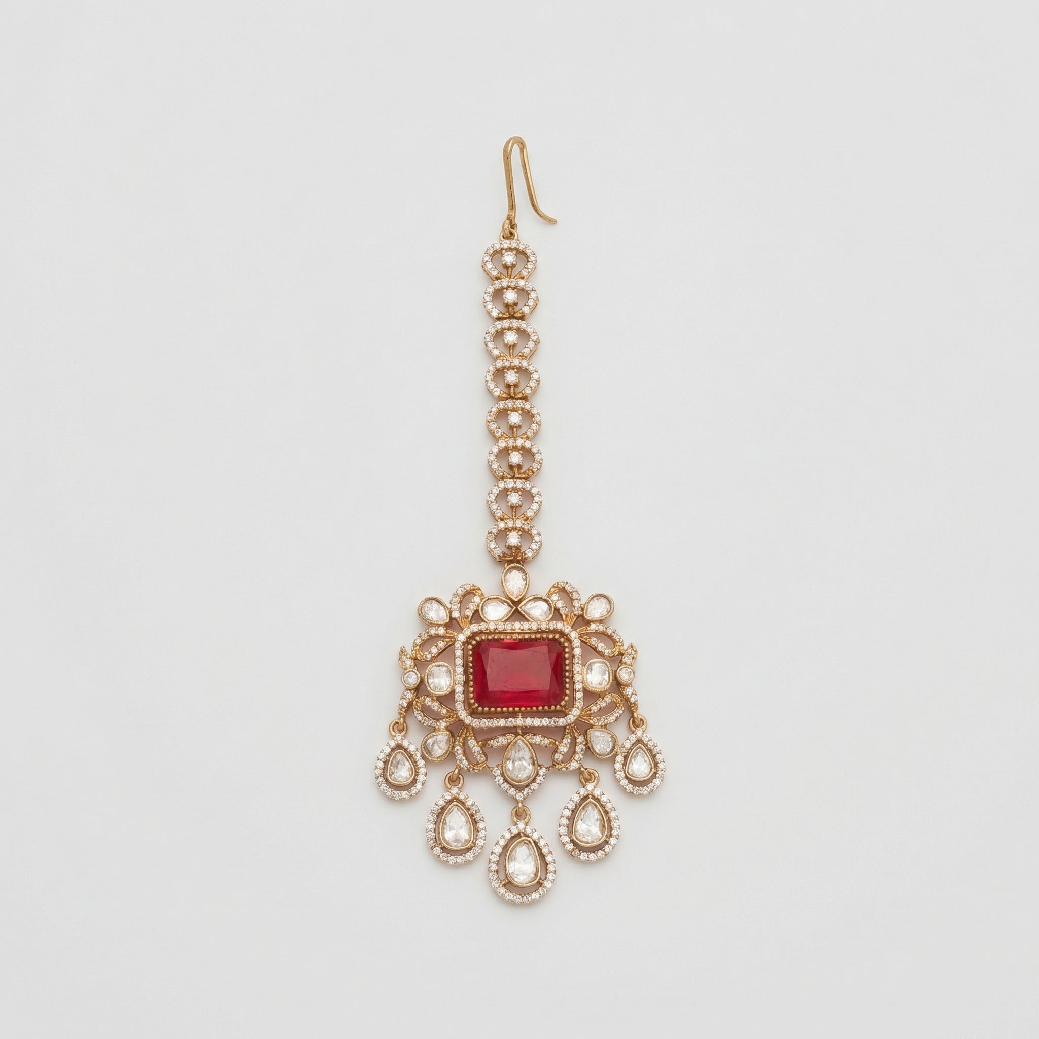 Kundan Ruby Tikka gold maang tikka with ruby red center and five teardrop crystal dangles on gray background