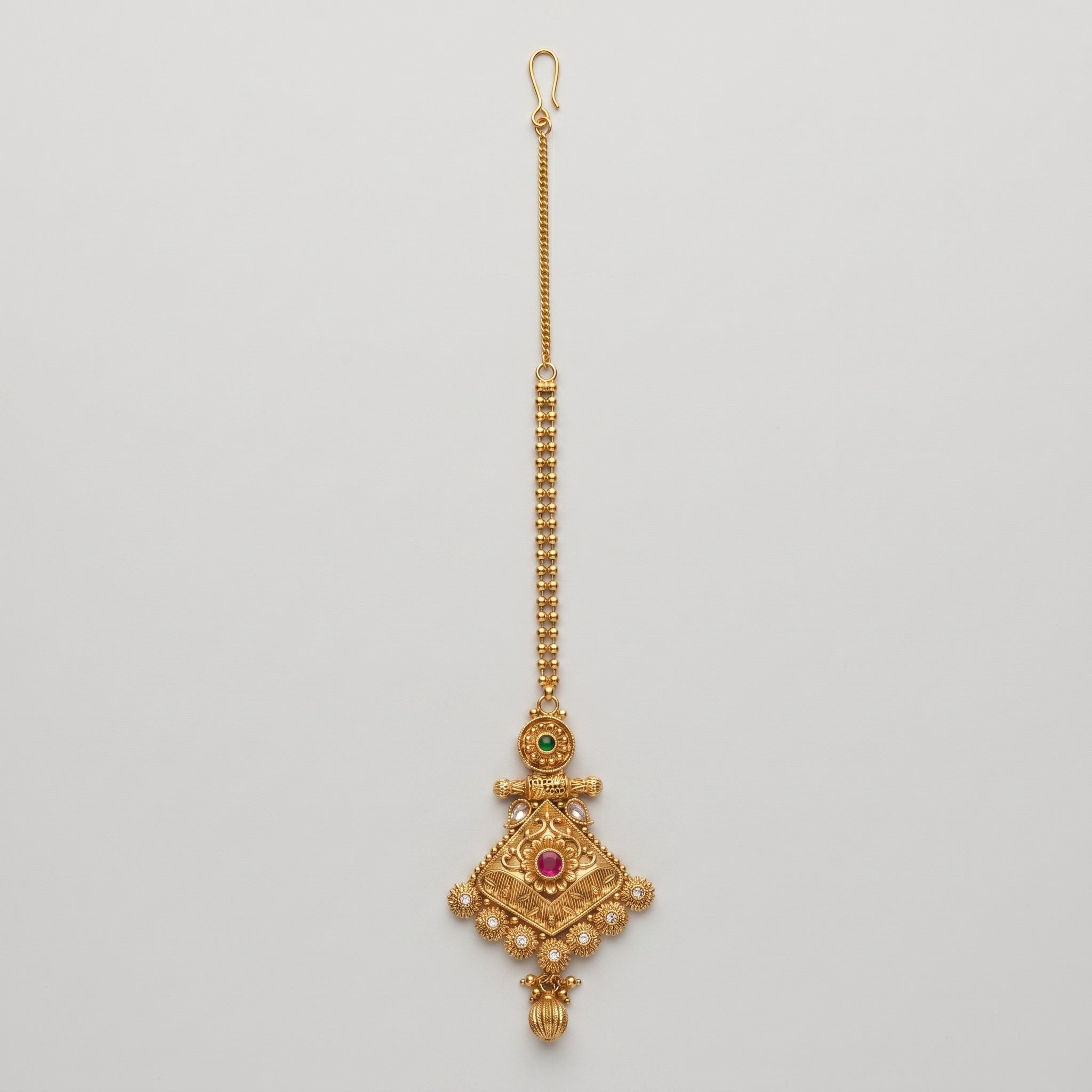 Jadau Ruby Tikka antique gold jadau maang tikka with ruby center on gray background