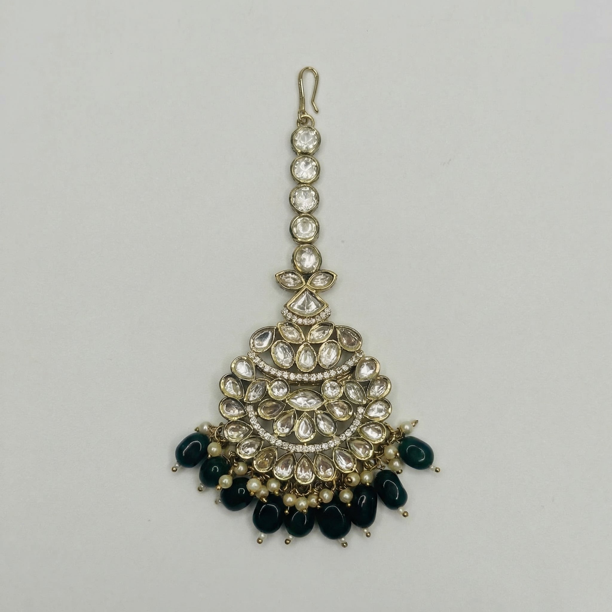 Priya Emerald Tikka gold fan maang tikka with green teardrop bead fringe on gray background