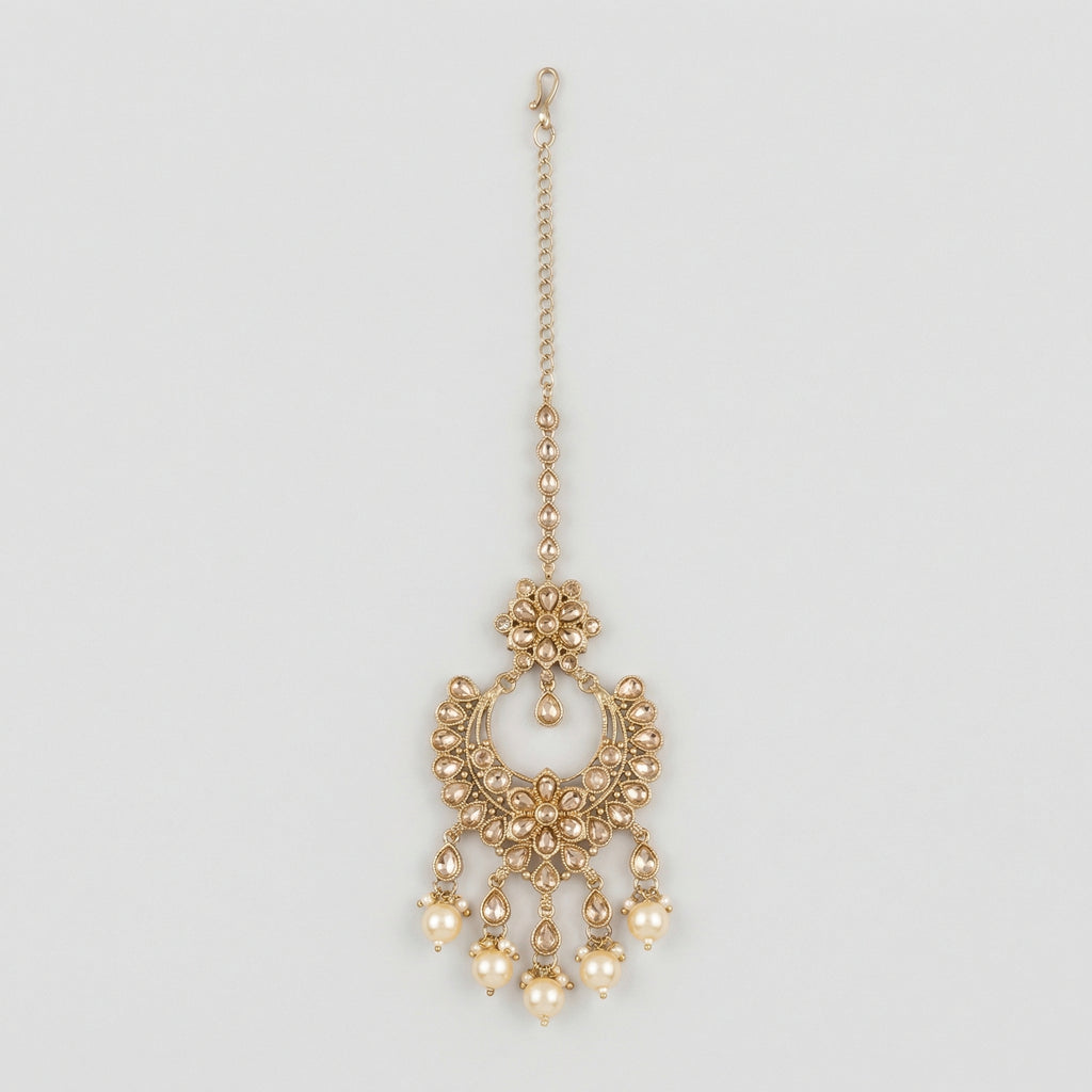 Kashi Pearl Tikka gold chandbali maang tikka with champagne stones and cream pearl drops on gray background