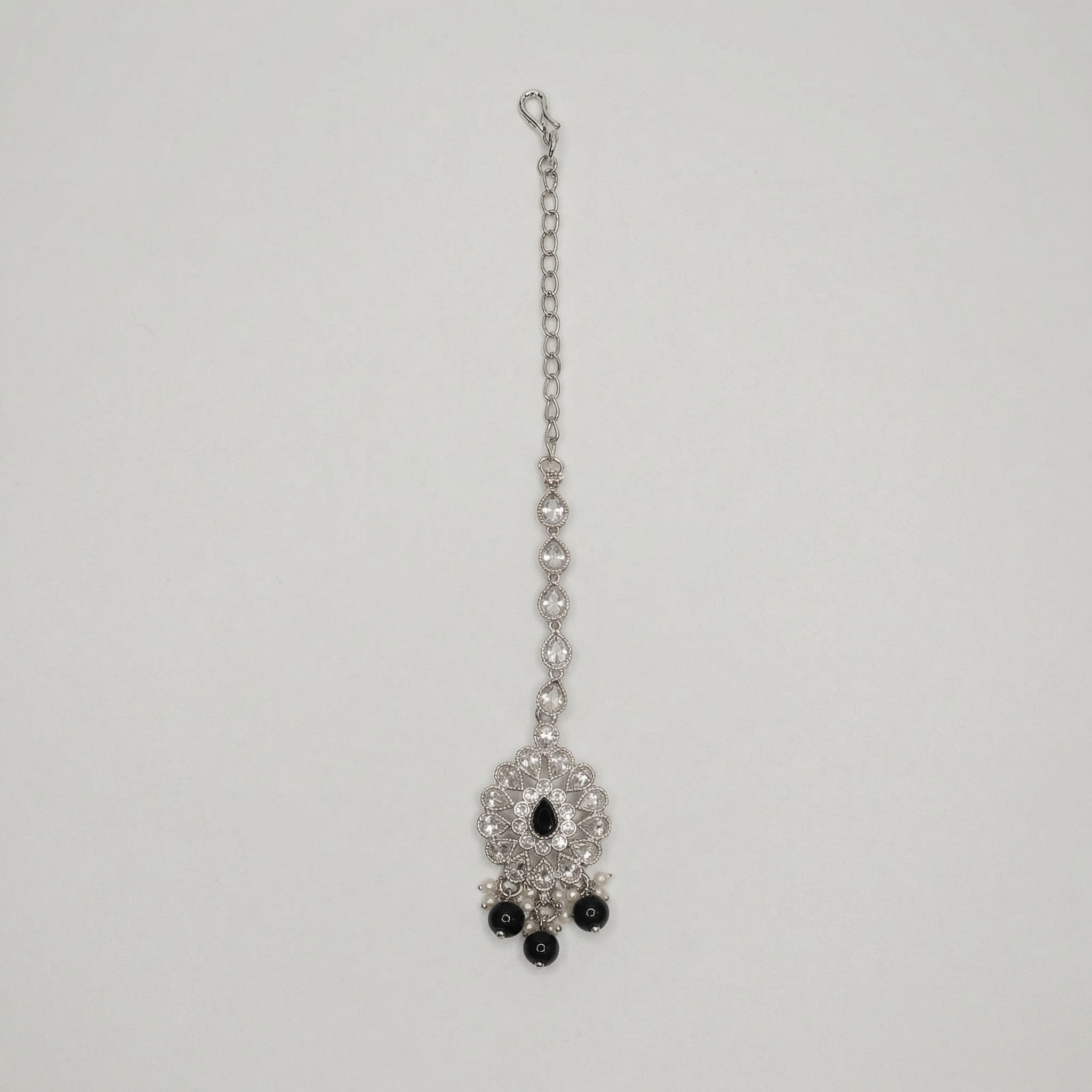 Sia Noir Tikka silver maang tikka with black center stone and black bead drops on gray background