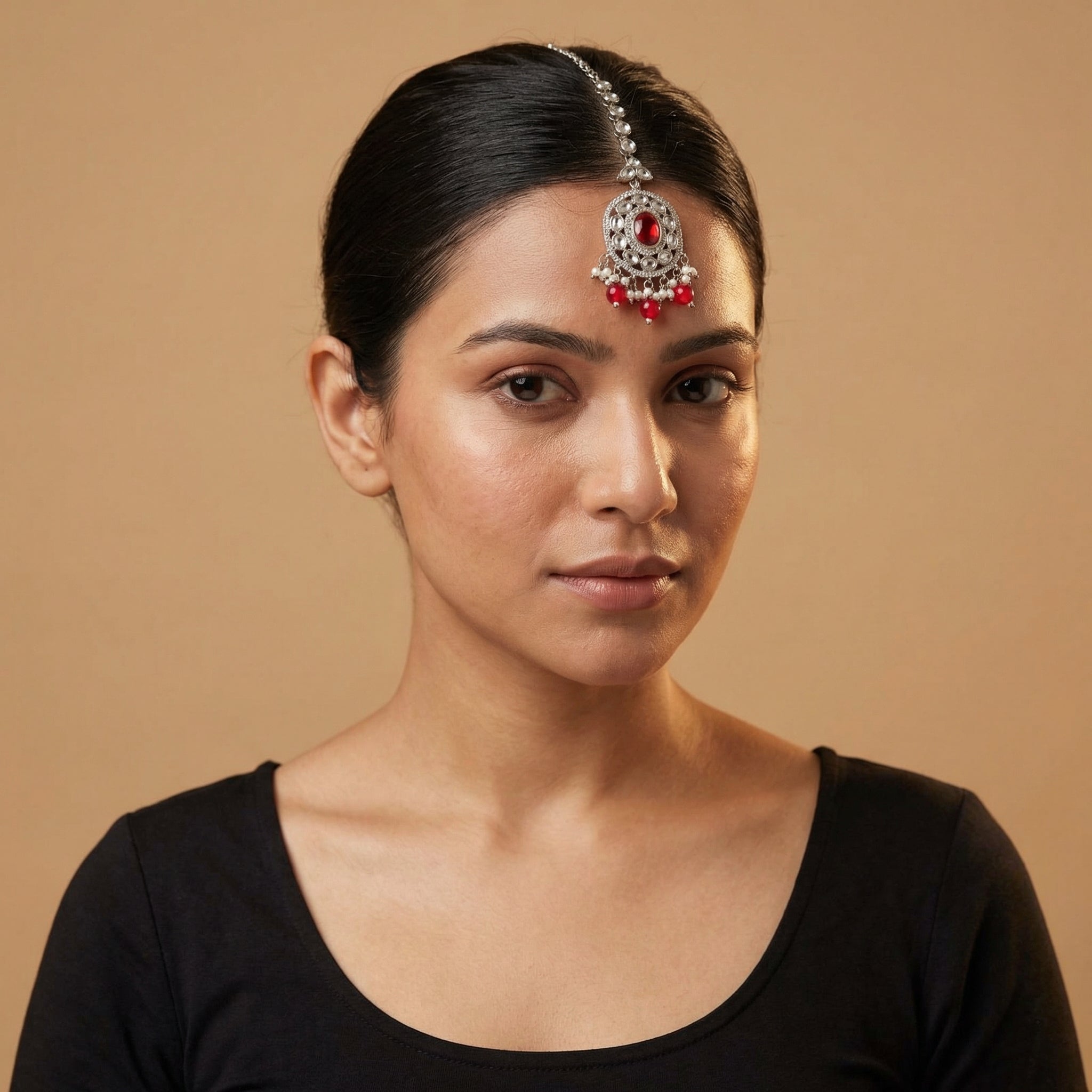 Ruby Bloom Tikka detail showing clear crystal chain, red center medallion, and dangling red beads