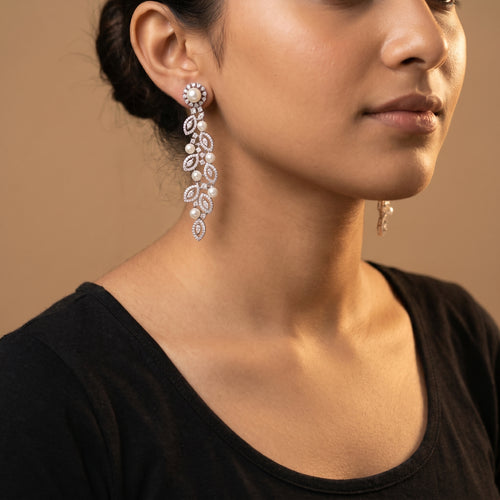 Bela Pearl Earrings detail showing pearl-stud post, cascading leaf frames, and scattered white pearl accents