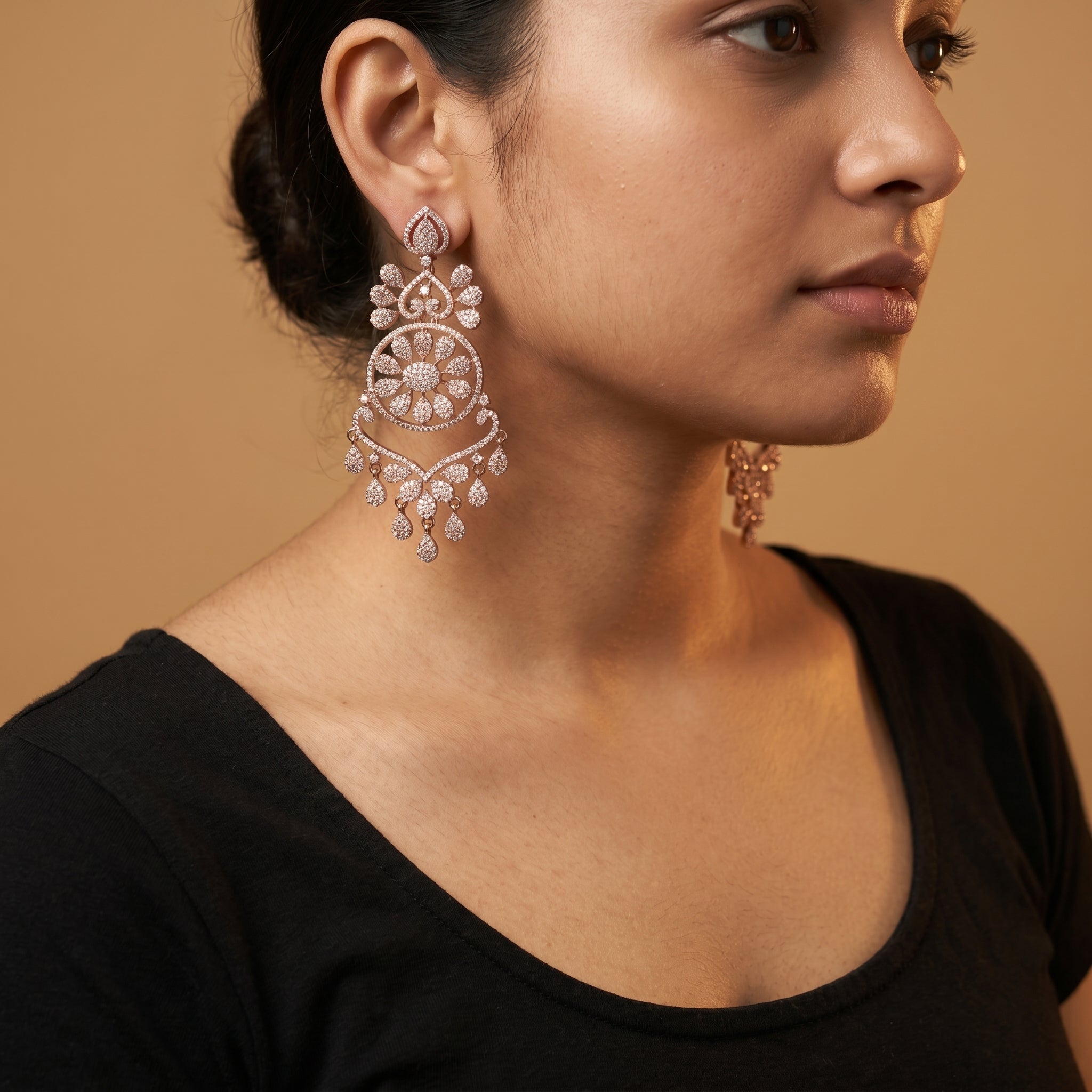 Roshni Earrings detail showing sunburst floral center, heart filigree tiers, and pavé crystal dangles