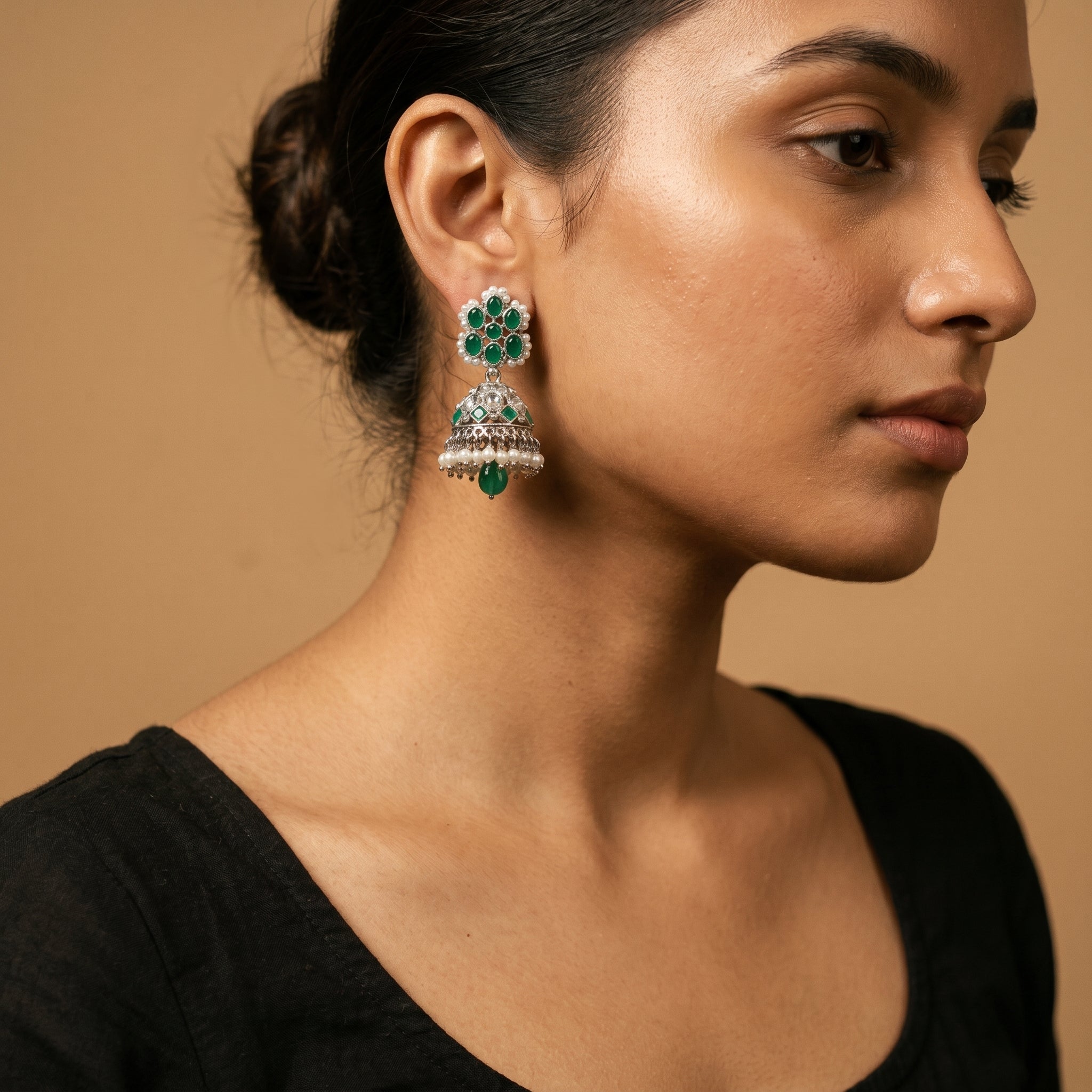 Rani Emerald Jhumka Earrings detail showing green cabochon stud, engraved bell, and pearl and emerald drops