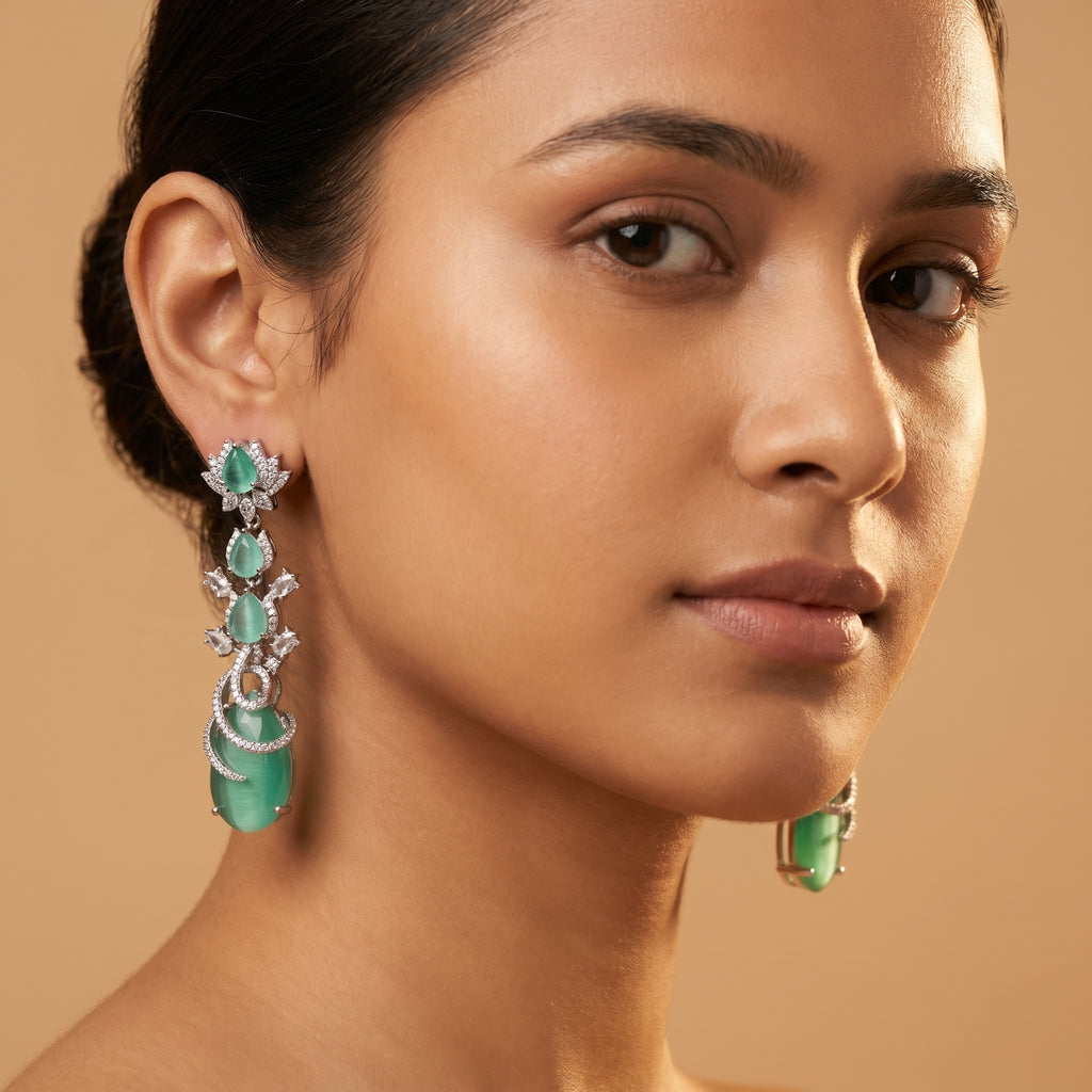 Sia Vine Earrings detail showing lotus floral stud, chatoyant green pear stones, and spiral pavé-wrapped bottom drop