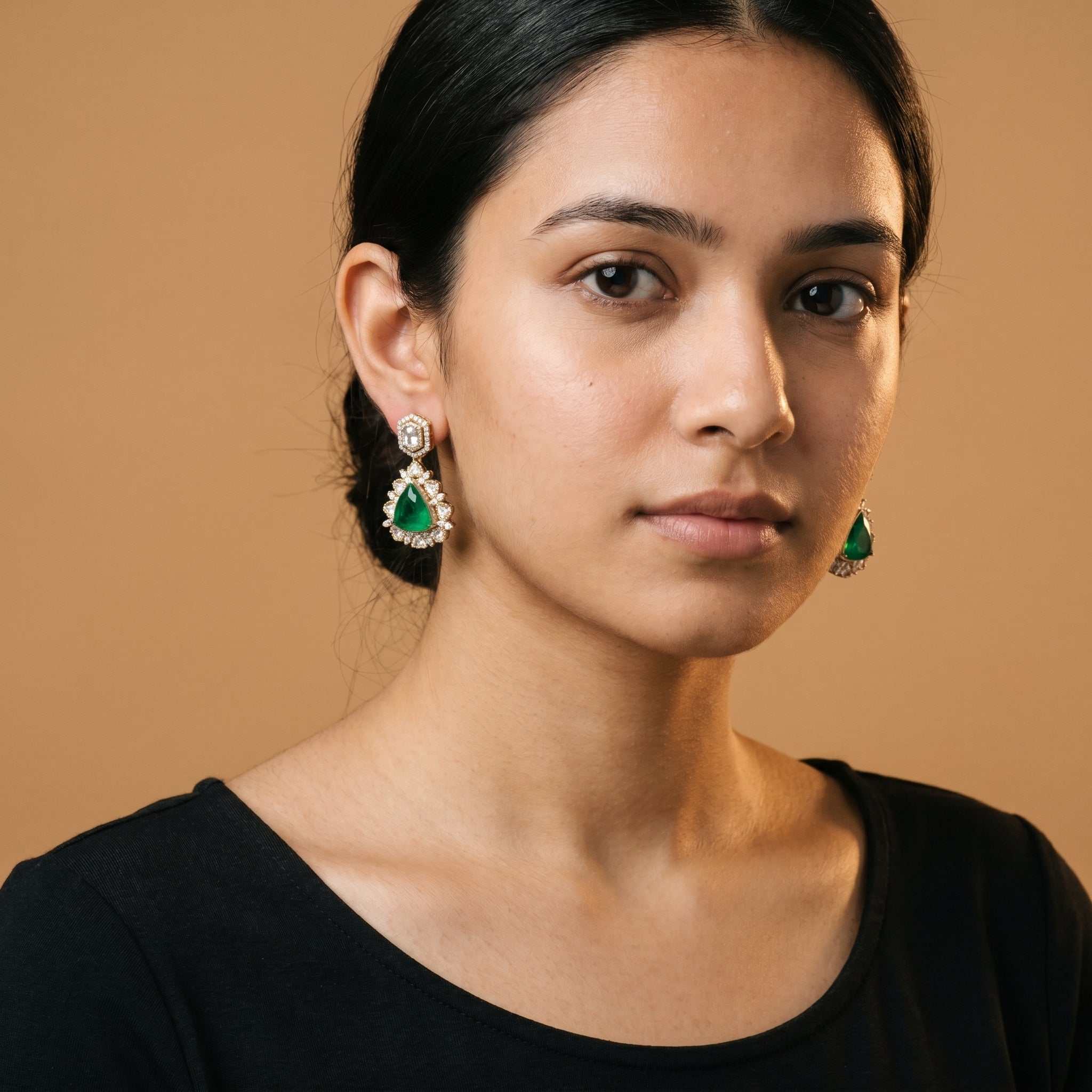 Panna Kiran Earrings detail showing scalloped halo and green center stone