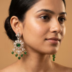 Rani Drop Earrings detail showing emerald-green oval center, pavé scalloped border, and green teardrop pearl fringe