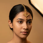Jadau Ruby Tikka detail showing embossed diamond plate and ruby-pink center stone