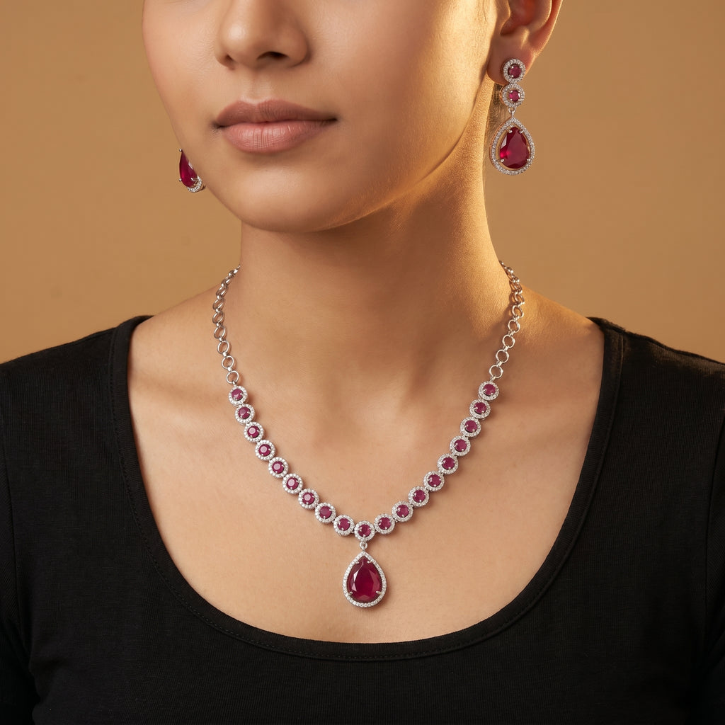 Aira Ruby Necklace Set detail showing halo-set round rubies and pear-cut drop pendant