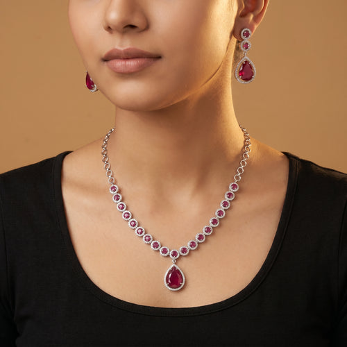 Aira Ruby Necklace Set detail showing halo-set round rubies and pear-cut drop pendant