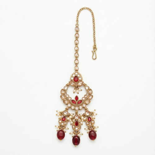 Chandrika Ruby Drop Tikka gold-tone kundan maang tikka with ruby drops and pearls on gray background