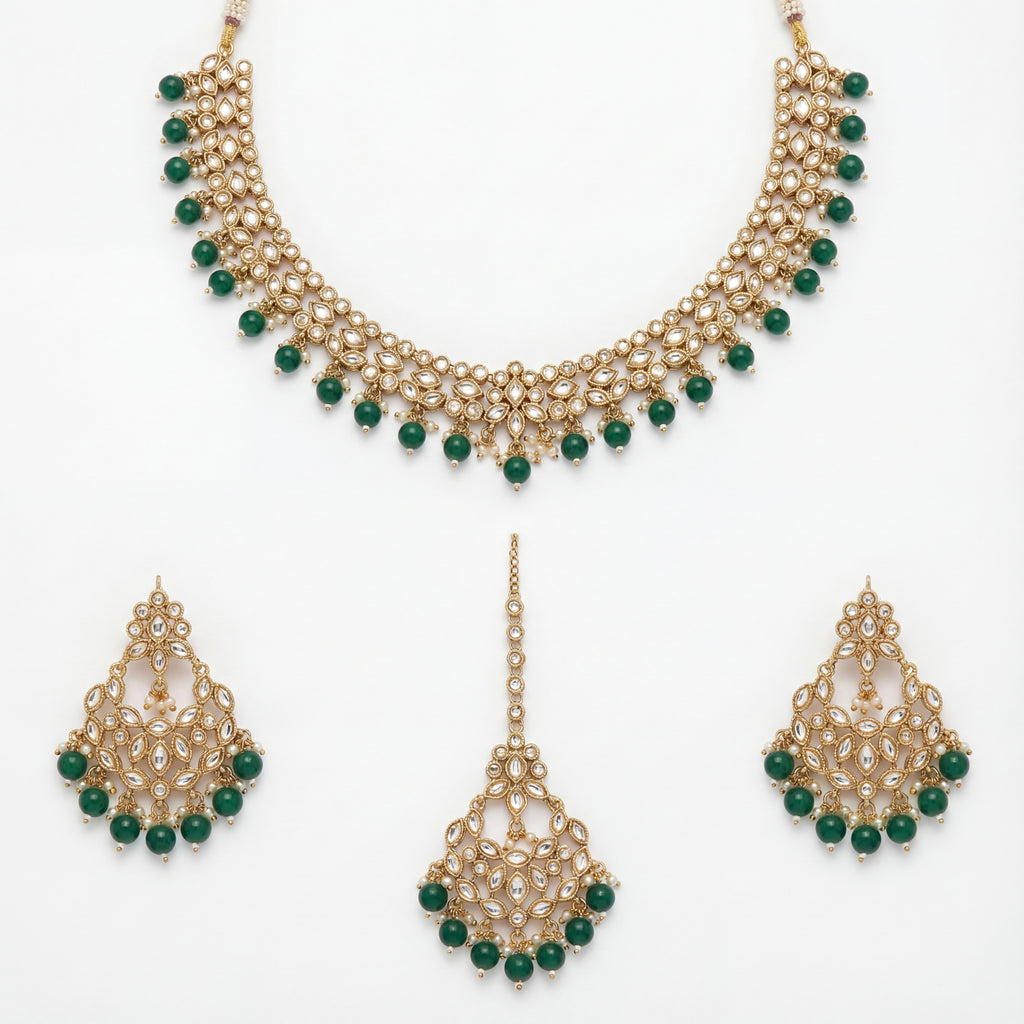 Anaya Emerald Kundan Necklace Set flat lay with gold-plated necklace, matching earrings, and tikka for Indian bridal