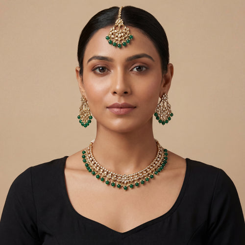 South Asian woman wearing Anaya Emerald Kundan Necklace Set with matching earrings and tikka — bridal look