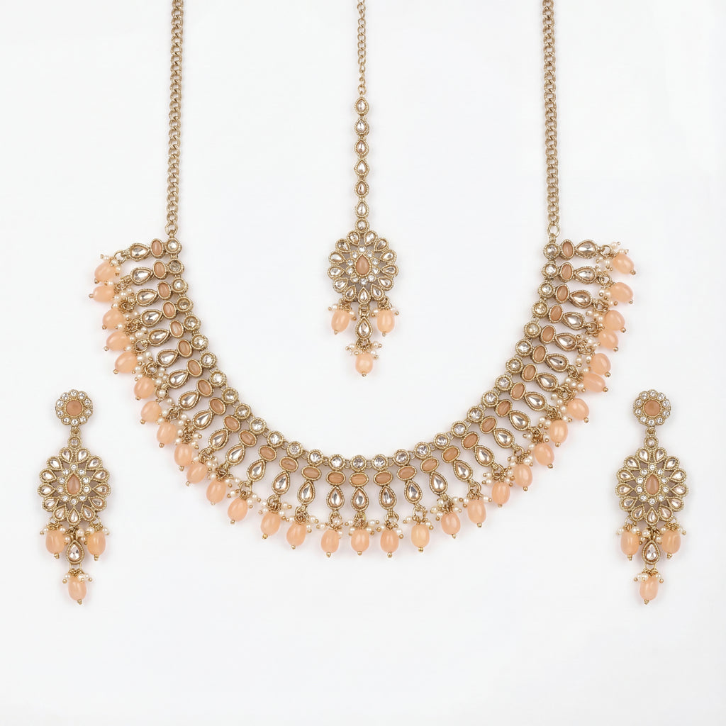 Studio flatlay of the gold-tone peach drop necklace with matching earrings