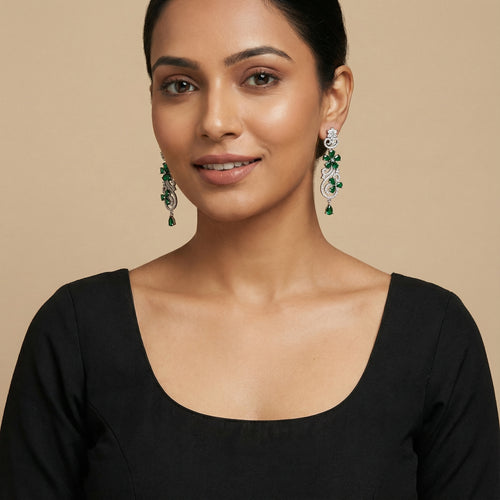 Close-up of Aira Emerald Luxe Earrings showing green stone accents and gold-plated finish