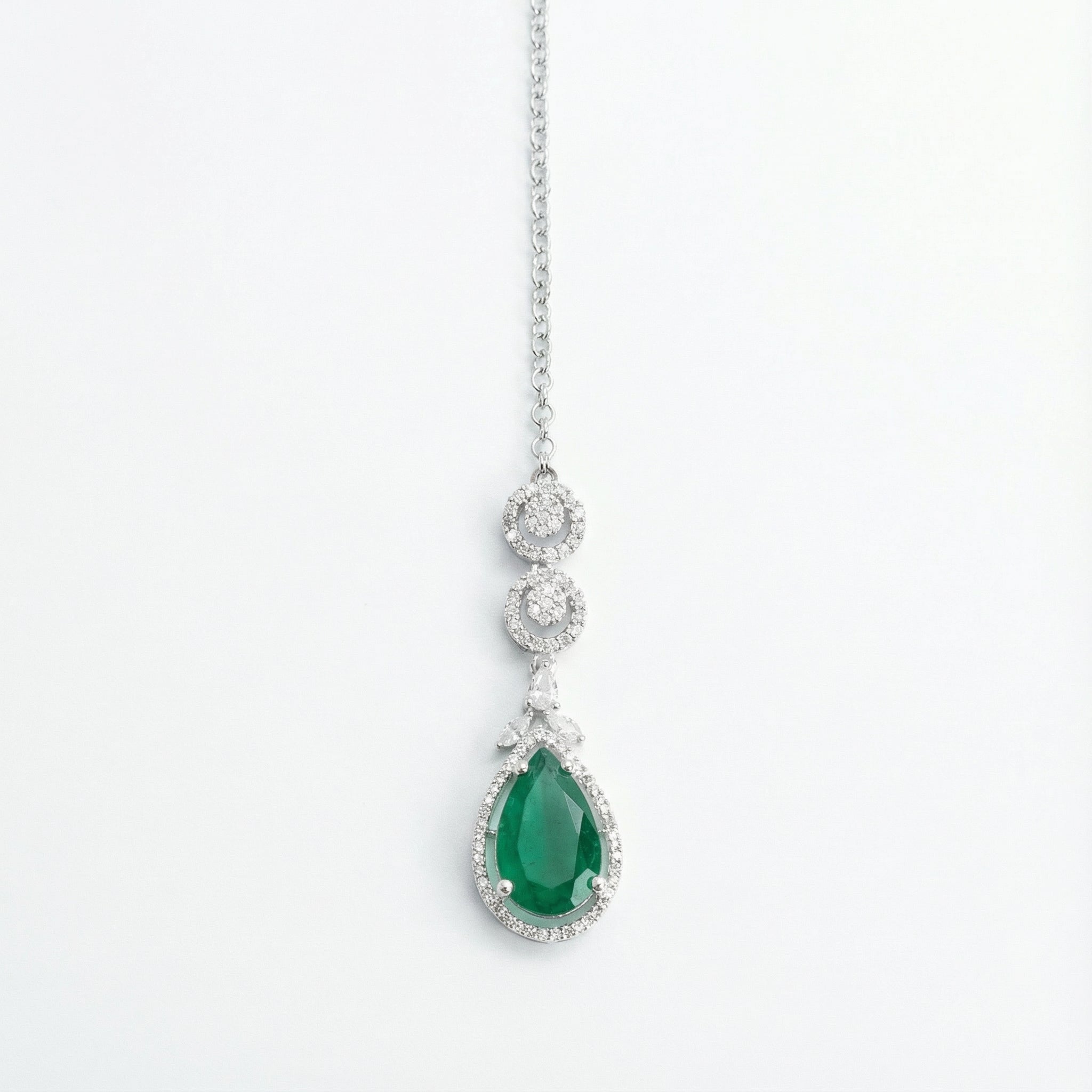 Zayna Emerald Statement Tikka silver-tone chain with emerald pear halo pendant on white background