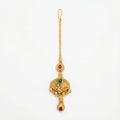 Ishara Leaf Crest Tikka antique gold maang tikka with green and red teardrop stones on gray background