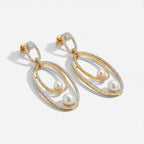 Orbitline Drop Earrings detail showing rhodium outer hoop, gold inner oval, and graduated pearl drops