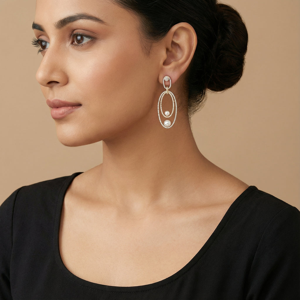 Orbitline Drop Earrings detail showing rhodium outer hoop, gold inner oval, and graduated pearl drops