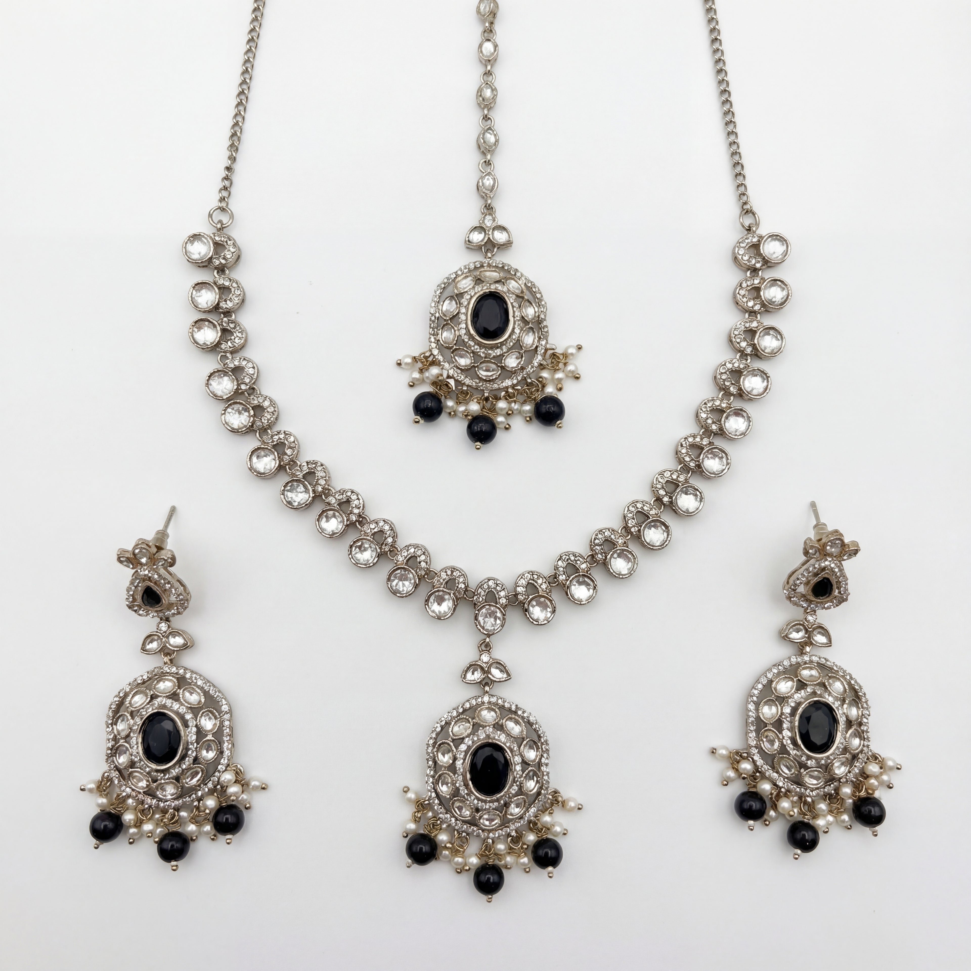 Eclipse Polki Necklace Set silver pendant necklace with black stones, earrings, and maang tikka on white background