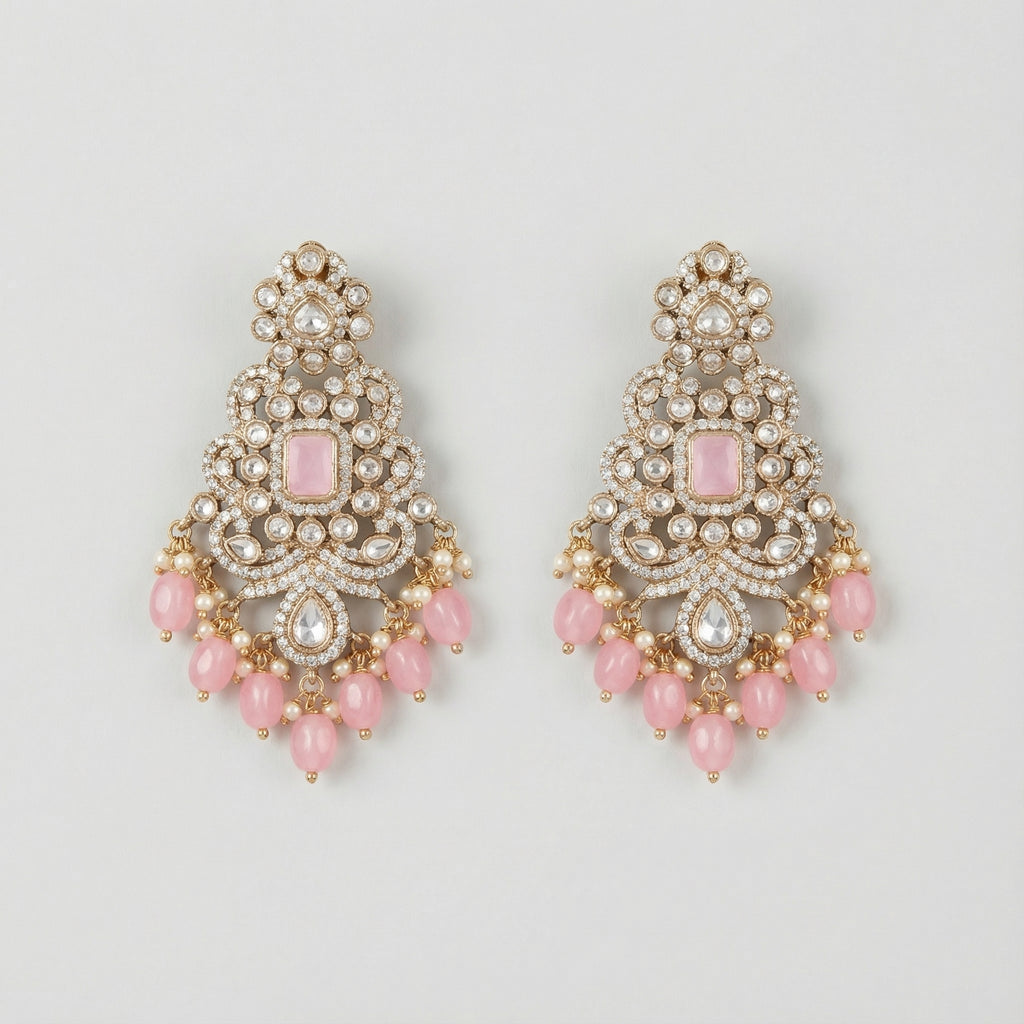 Pink Noor Kundan Earrings gold-tone chandelier drops with pink cabochon centers and pearl fringe on gray background