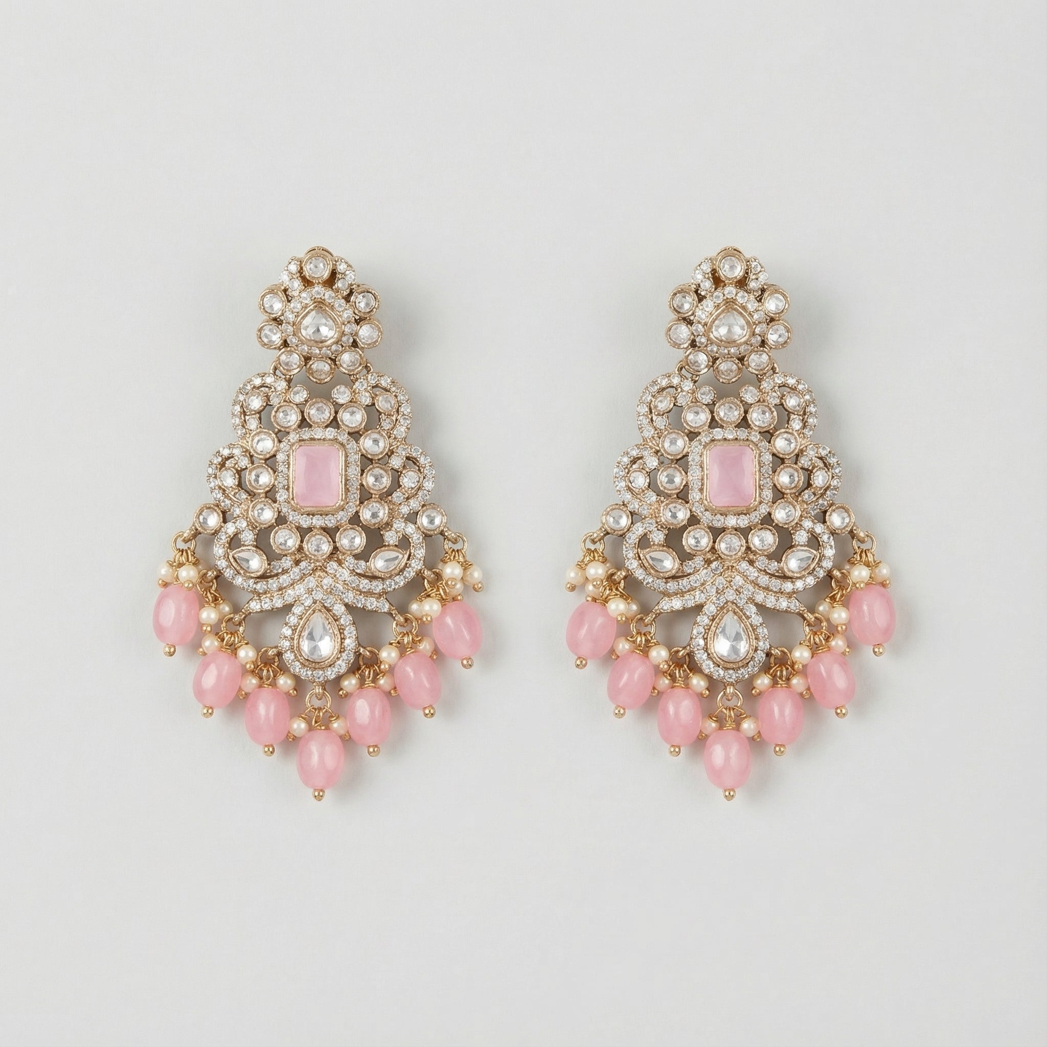 Pink Noor Kundan Earrings gold-tone chandelier drops with pink cabochon centers and pearl fringe on gray background