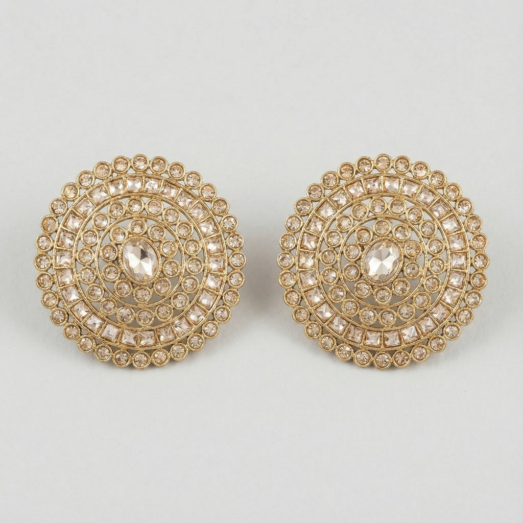 Golden Noor Disc Earrings large gold-tone circular crystal stud earrings on gray background
