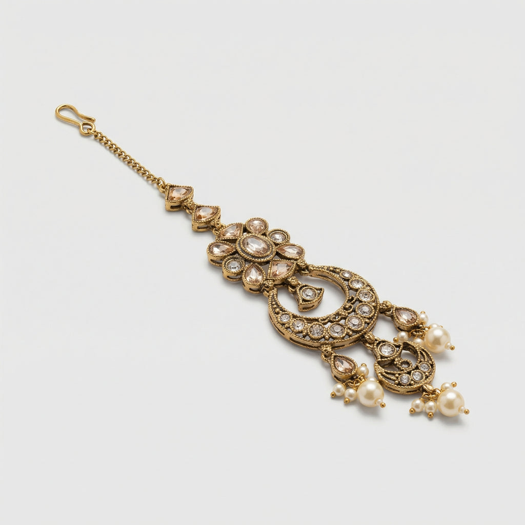 Ivory Aura Kundan Tikka detail showing floral kundan cluster, ornate crescent, and pearl-tipped drops