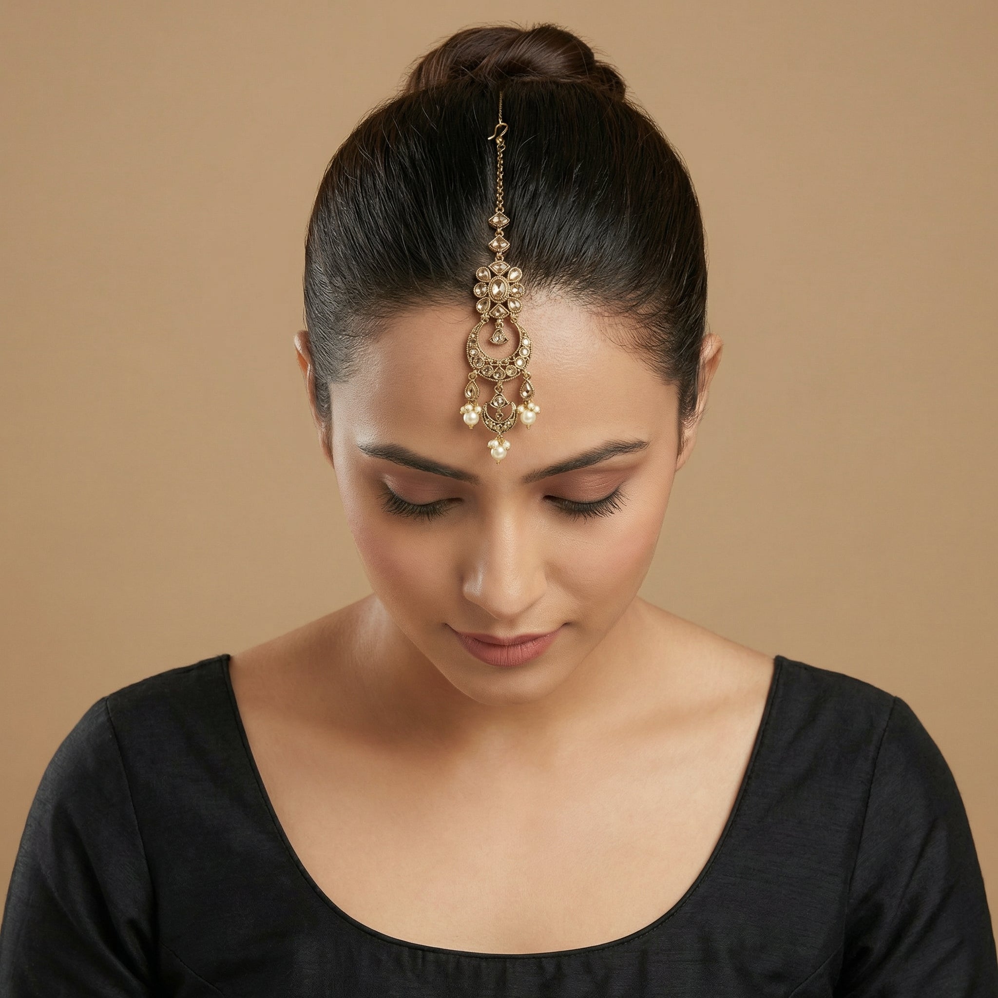 Ivory Aura Kundan Tikka detail showing floral kundan cluster, ornate crescent, and pearl-tipped drops