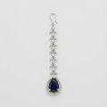Onyx Halo Drop Tikka silver-tone maang tikka with dark blue teardrop pendant and clear halo on gray background