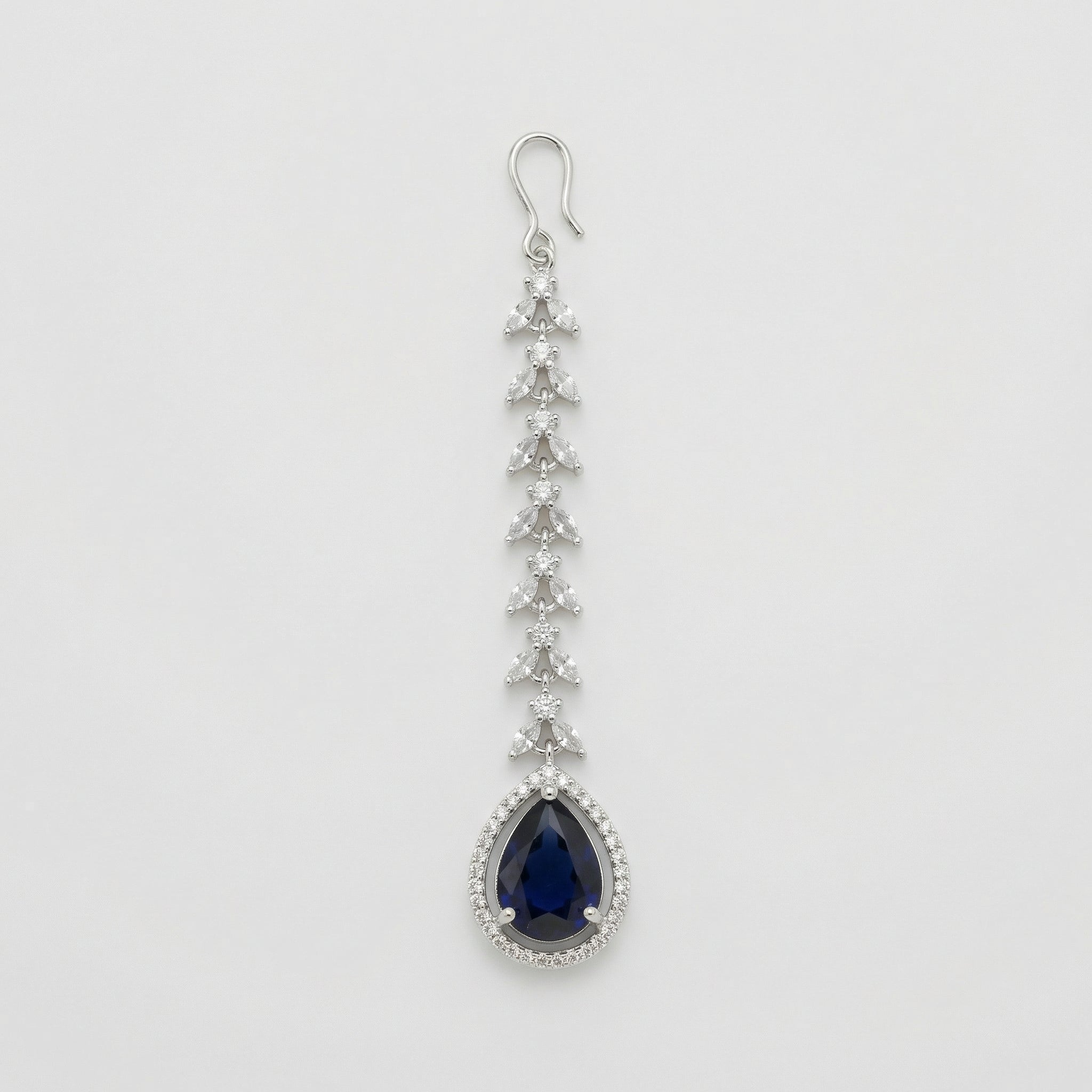 Onyx Halo Drop Tikka silver-tone maang tikka with dark blue teardrop pendant and clear halo on gray background