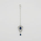 Sapphire Drop Crystal Tikka silver maang tikka with navy blue center stone on gray background